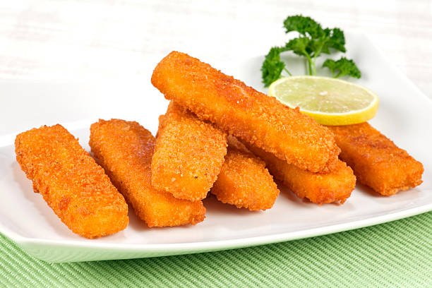 Fried fish fingers on plate. Selective focus, shallow DOF.